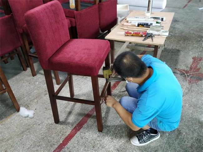 深圳lavo酒吧實木布藝軟包吧椅由海德利設計生產，師傅正在做最后組裝